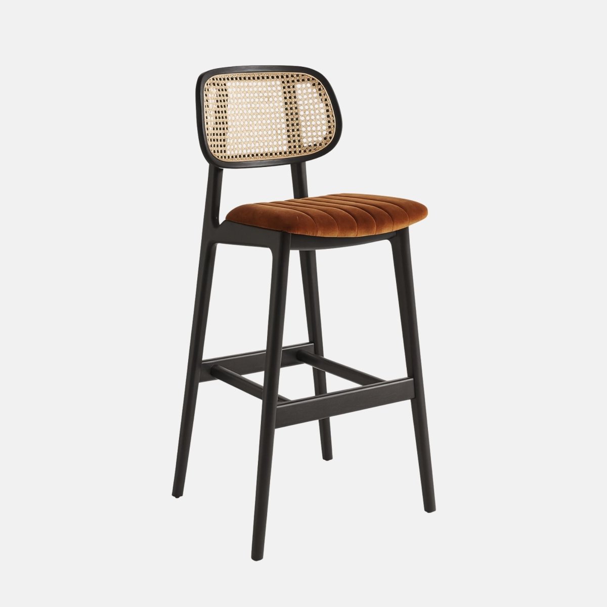 A modern bar stool with a sleek black wooden frame, a woven cane backrest, and a copper velvet upholstered seat featuring fluted detailing, photographed against a plain white background