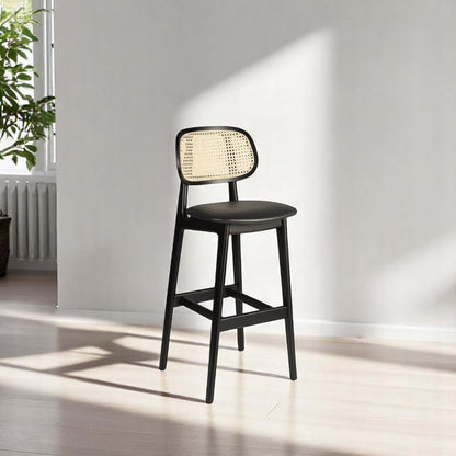alt="Modern kitchen stool with black wood frame, rattan backrest, and comfortable black leather seat"