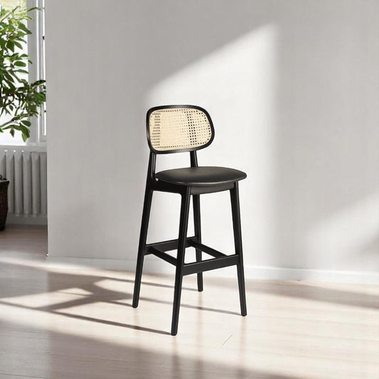 alt="Modern kitchen stool with black wood frame, rattan backrest, and comfortable black leather seat"