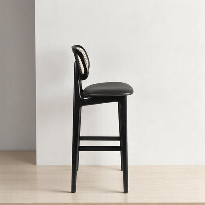 alt="Sleek kitchen stool with black wood frame, rattan backrest, and black leather seat for a sophisticated look"