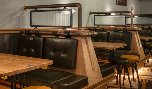 Restaurant booth seating with leather banquettes, wooden tables, and modern lighting.