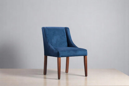 alt="Blue square dining chair upholstered in soft velvet with medium oak wooden legs"