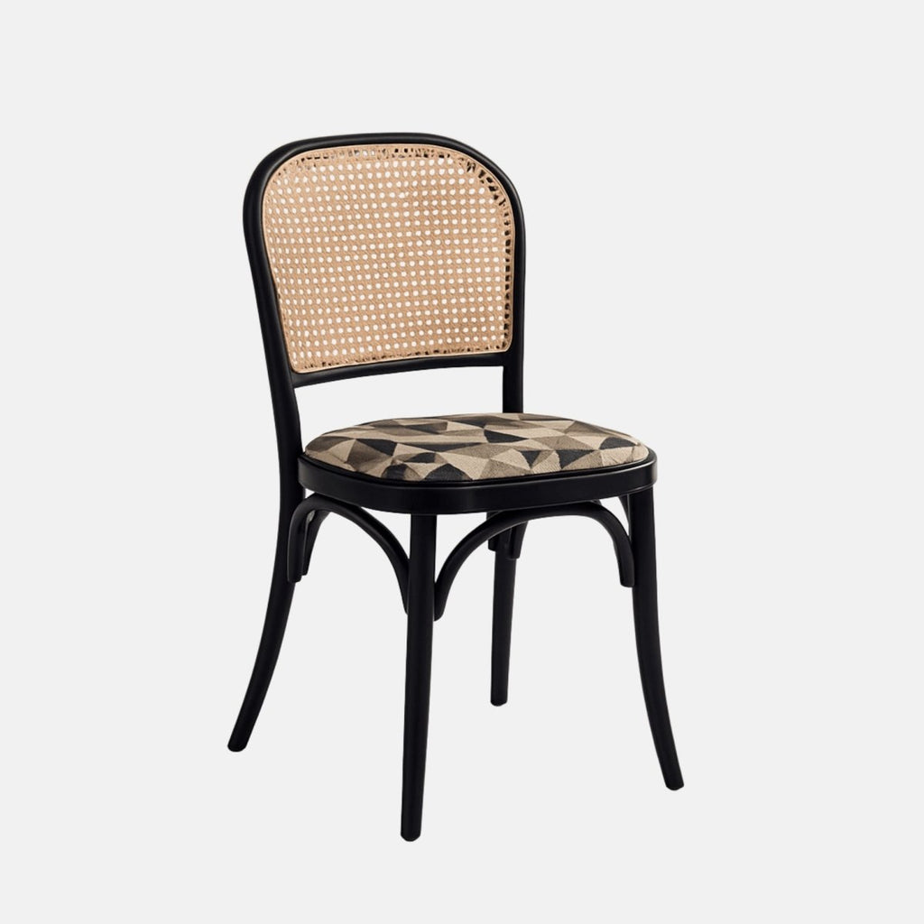 A black bentwood dining chair with a natural cane backrest and a cushioned seat upholstered in a beige and black geometric patterned fabric, shown from a straight side angle against a neutral background.