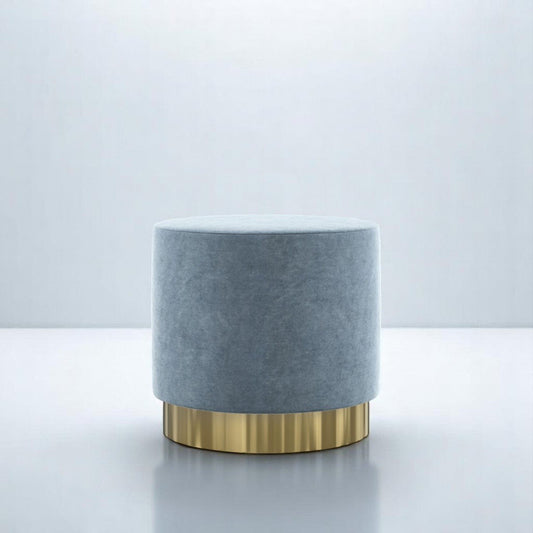 alt="Luxurious round pouffe in soft grey fabric with gold base, perfect for adding a touch of elegance"