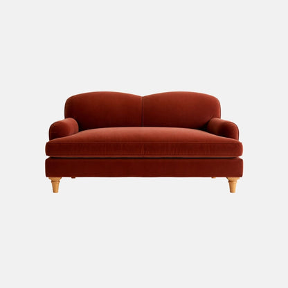 Elegant two-seater sofa in rich rust-red upholstery with a softly curved back, compact arms, and light wooden legs, ideal for modern residential or hospitality interiors