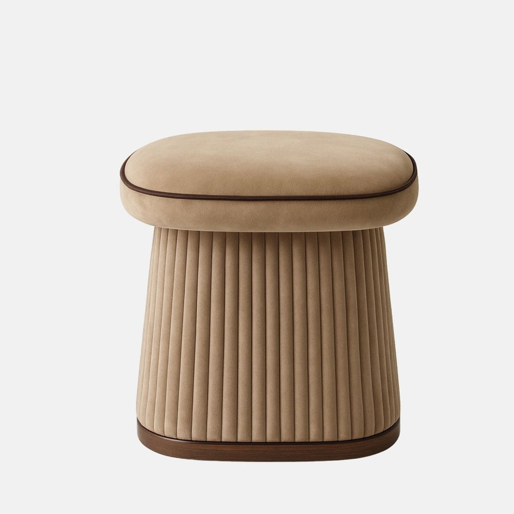 Beige velvet pleated stool with rounded cushioned seat and wooden base modern vanity stool or upholstered ottoman for bedroom, lounge, or hospitality interiors.