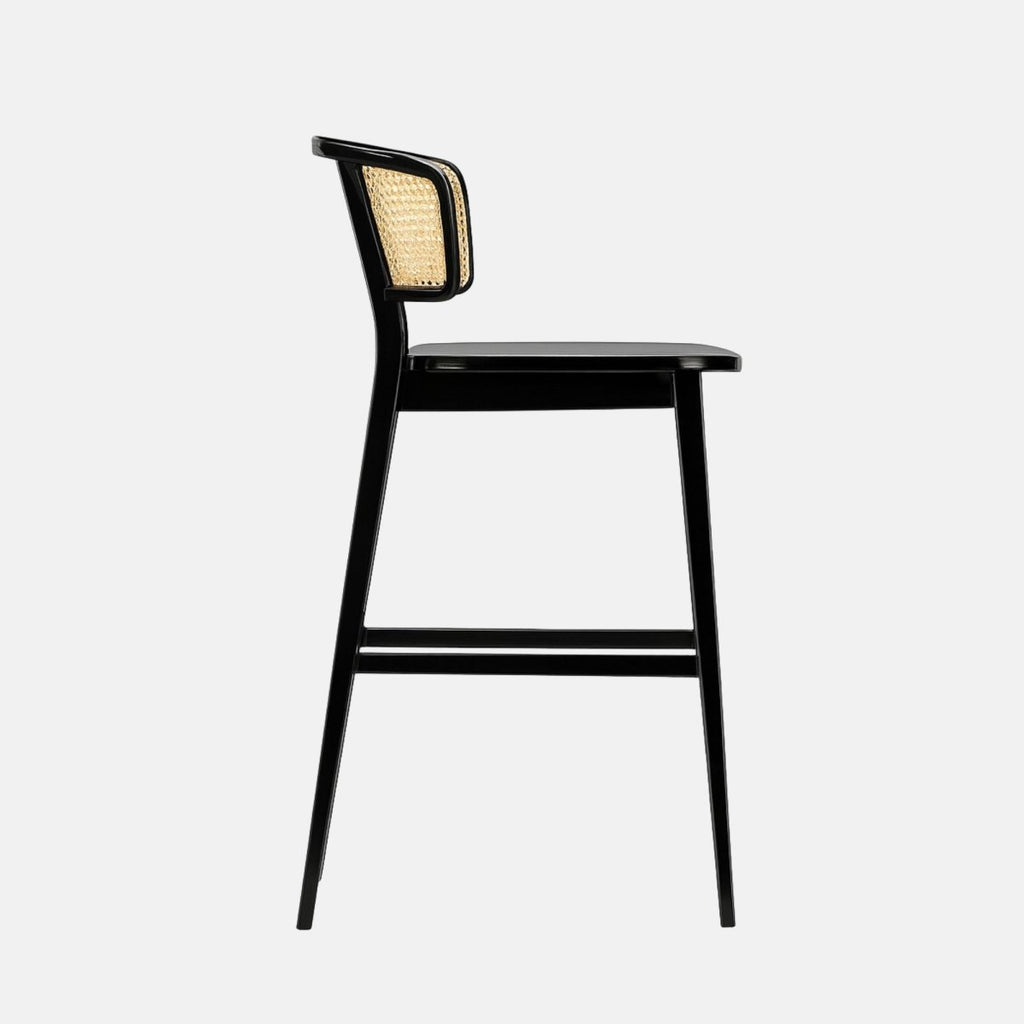 Modern bar stool with a glossy black wooden frame and a curved natural cane backrest, featuring a smooth black seat and footrest, set against a light grey background.