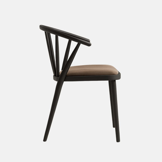 A modern accent chair with a sleek matte black wooden frame, featuring a gently curved backrest supported by slender vertical slats and angled rear legs. The seat is upholstered in light milky chocolate brown velvet with subtle vertical stripe stitching, offering a soft and refined contrast to the bold frame. The design blends contemporary elegance with ergonomic comfort.
