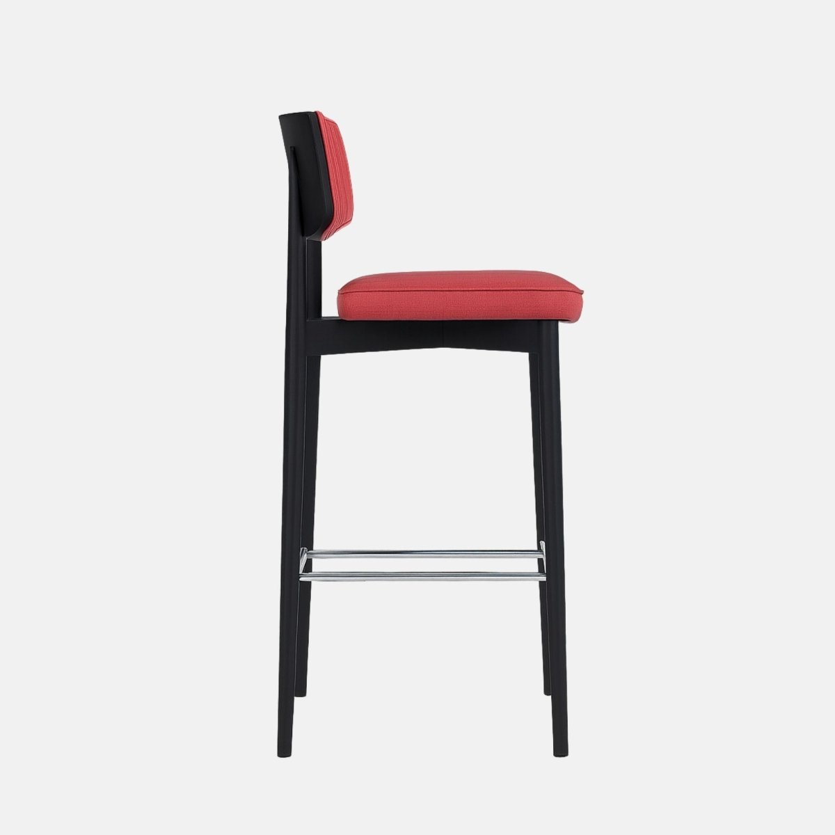 Modern bar stool with a black wooden frame, coral red upholstered seat and backrest featuring vertical channel stitching, and metal footrest.