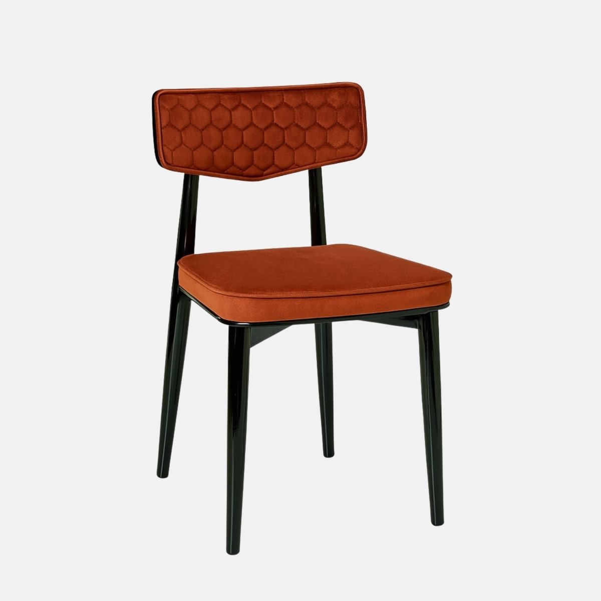 Modern dining chair with a black wooden frame and legs, featuring a burnt orange upholstered seat and a hexagon-patterned backrest, set against a light grey background