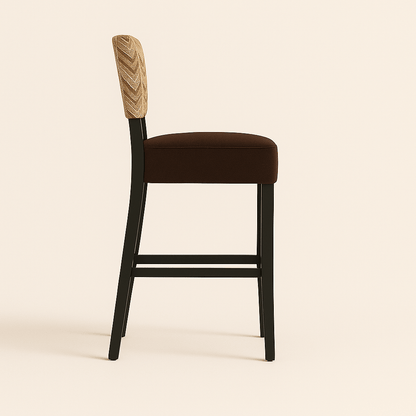 Bar stool with a modern design featuring a cushioned dark brown seat, a chevron-patterned upholstered backrest in beige and brown tones, black wooden legs, and a brass gold footrest, set against a soft, light coloured background.