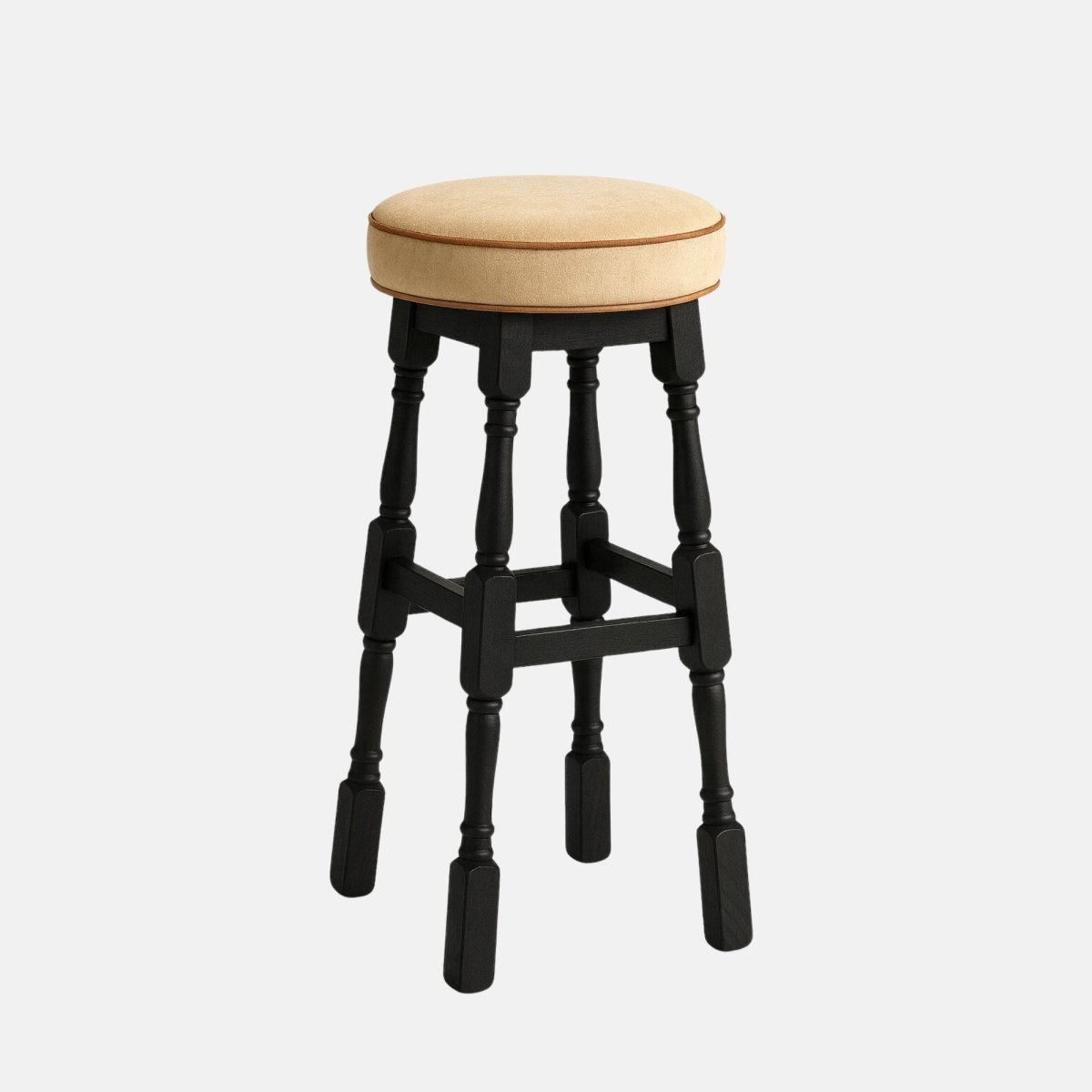 Tudor High Stool – tall black wooden bar stool with a round beige upholstered seat and turned legs, ideal for restaurants, bars, and modern interiors.