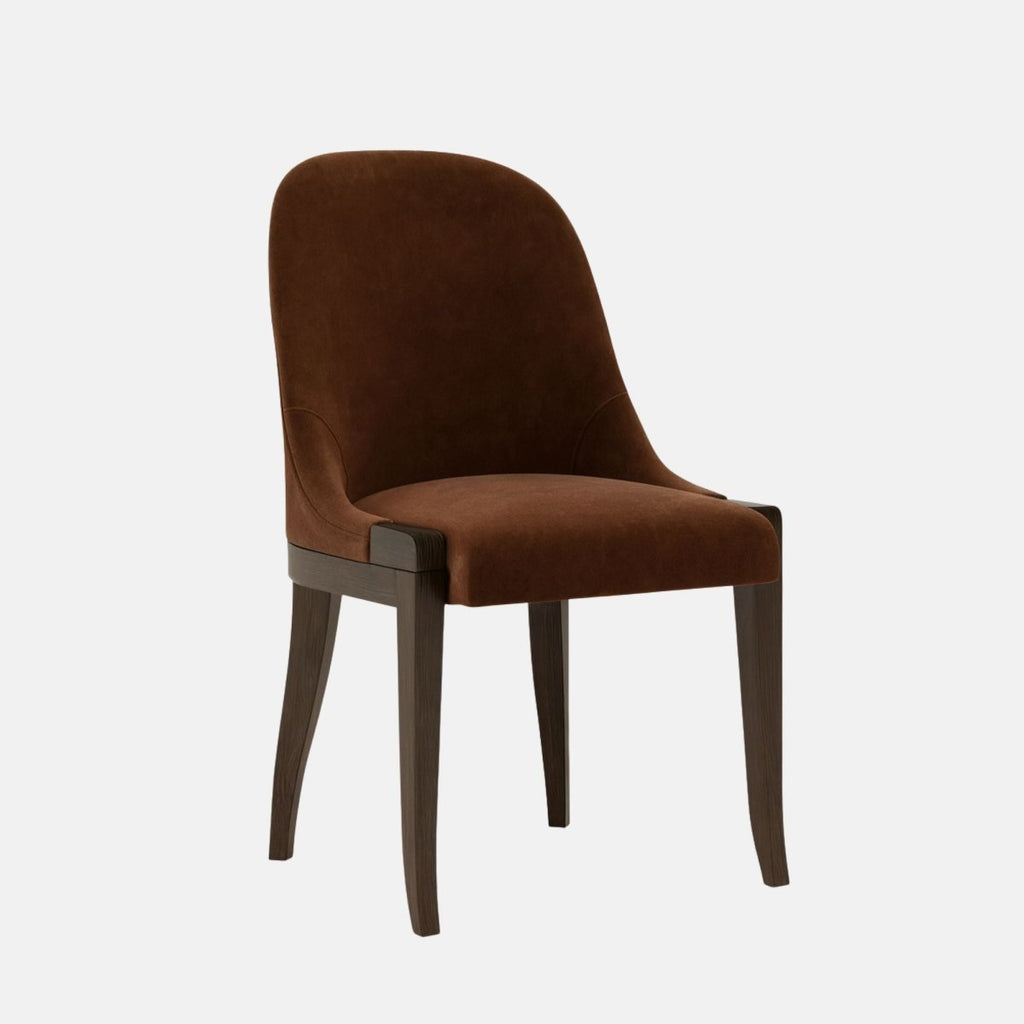Upholstered dining chair in deep brown velvet with a softly curved backrest and cushioned seat, supported by dark wooden legs, shown on a white background