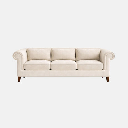 Elegant three-seater sofa with cream upholstery, rolled arms and cushioned seats, featuring wooden legs, ideal for lounges, hotels, and classic interiors