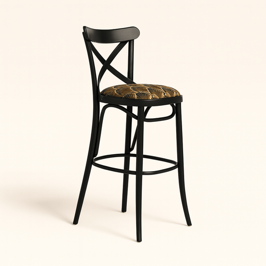 A modern black wooden barstool with an X-shaped backrest and gently curved legs, featuring a round cushioned seat upholstered in a gold and brown Art Deco patterned fabric, set against a plain beige background with a soft shadow.