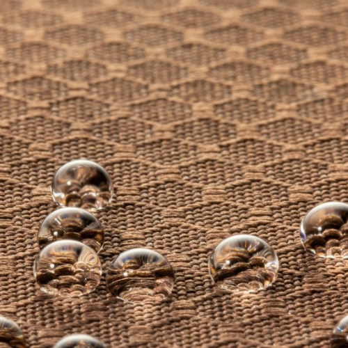 Water droplets on brown upholstery fabric demonstrating water-resistant textile surface.