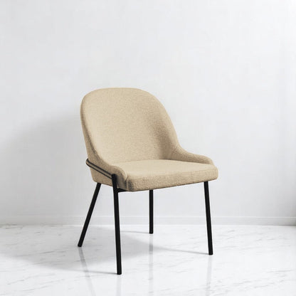 alt="Soft cream upholstered dining chair with comfortable padding and sleek black powder-coated legs"
