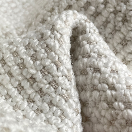 Close-up of white boucle upholstery fabric showing thick woven texture and soft loops