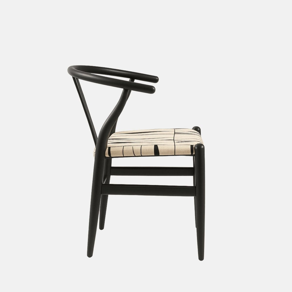 Modern black wooden armchair with a curved backrest, open Y-shaped support, and a beige cushioned seat featuring a black abstract line pattern.